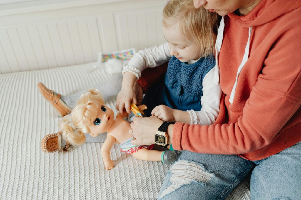 the example of everyday Mandarin phrases get child speaking, which shows a mom and a girl are playing with a doll but practise Mandarin